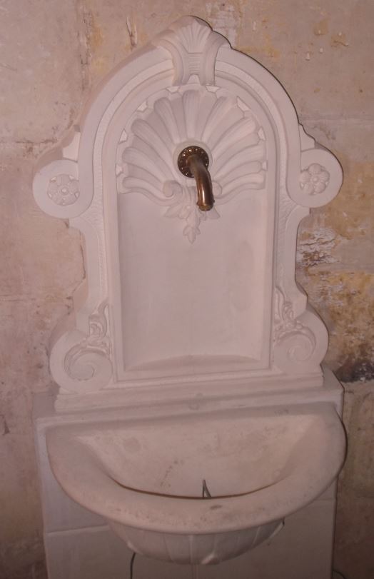 Brass spout fitted inot a stone fountain
